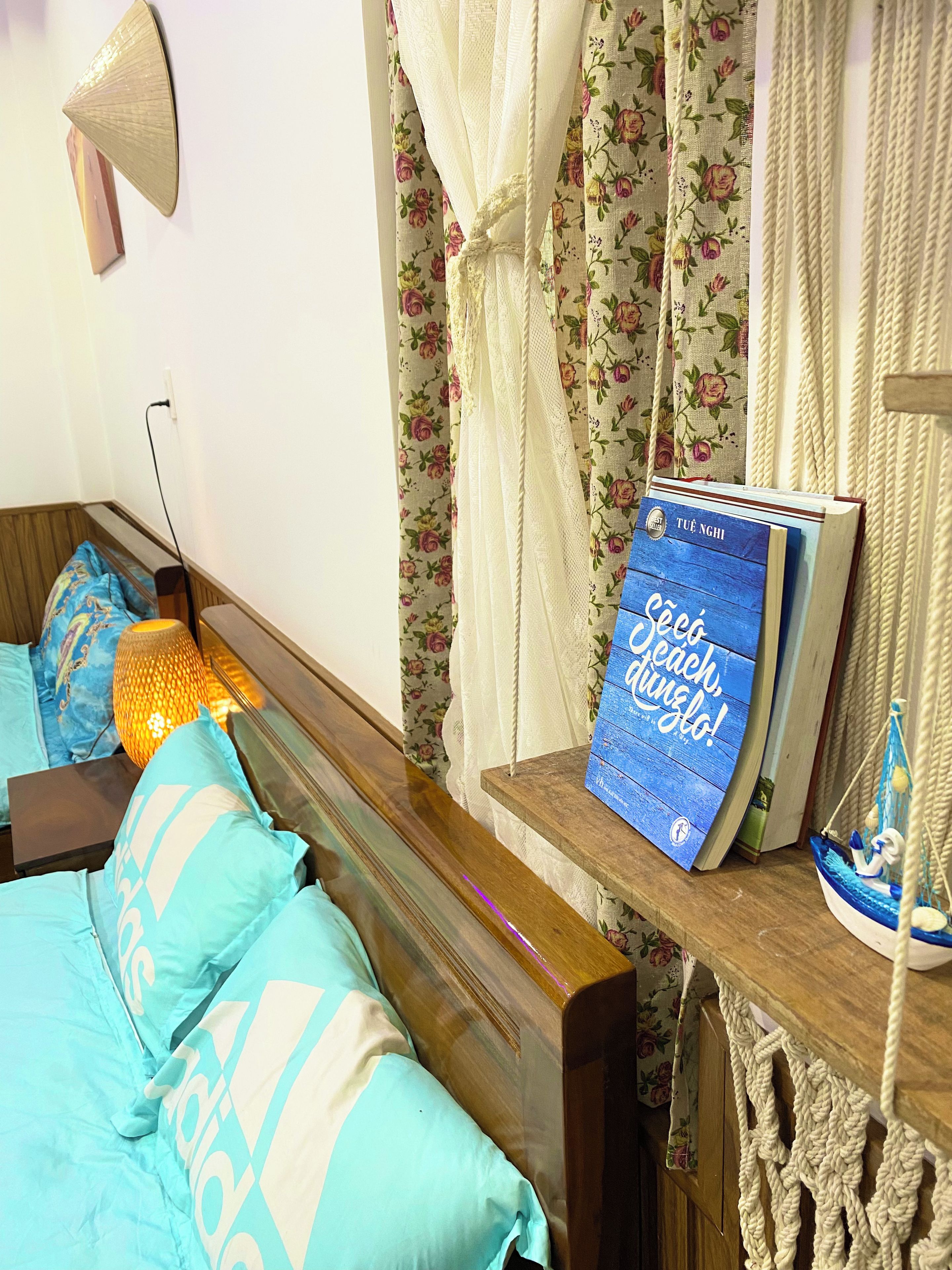 Une chambre à coucher avec un lit en bois, une table de chevet sur laquelle se trouve un livre et une lampe.
