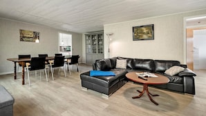 Ein modernes Wohnzimmer mit einer Eckcouch, einem Esstisch mit Stühlen und einem kleinen Couchtisch.