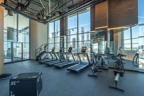 Een moderne fitnessruimte met loopbanden, hometrainers en krachttrainingapparatuur.