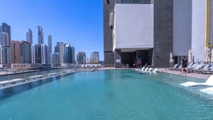 Piscina com paisagem urbana ao fundo.