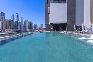 A swimming pool with a city skyline in the background.