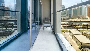 Uma varanda com vista para a paisagem urbana, incluindo um edifício alto.