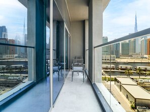 A balcony with a view of a cityscape, including a tall building.