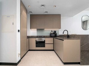 A modern kitchen with built-in appliances, a sink, and a microwave. - Exceptional 1Bedroom w/ Premium Amenities (Dubai)