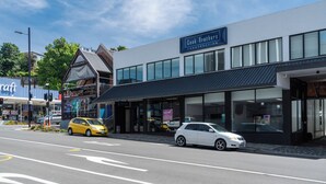 A modern building with a sign for 'Cook Brothers Construction' and a 'No. 1 Distillery' across the street. - City Centre Apartment on Hanover - Studio 1 (Dunedin)