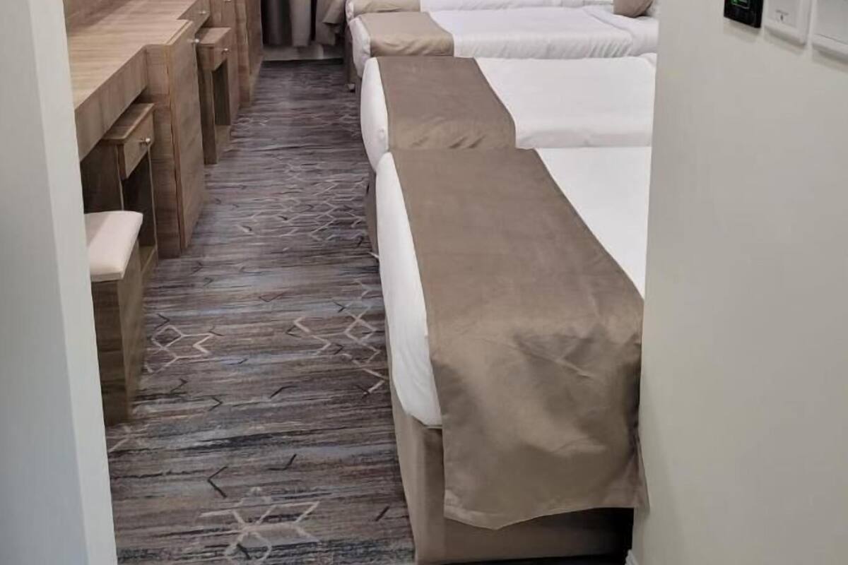 Una habitación de hotel con una cama grande, un escritorio y un televisor montado en la pared.