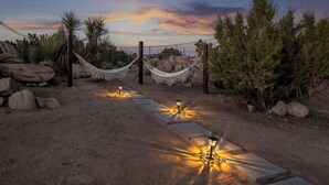 A pathway with a hammock and lanterns, surrounded by rocks and desert vegetation. - Bijou • Romantic Sanctuary, Hot Tub in Boulders (Yucca Valley)