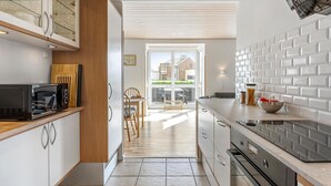 Una cocina moderna con microondas, armarios y vistas al exterior.