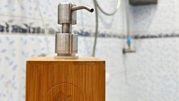 Un objeto de madera con una bomba metálica en la parte superior, sobre una superficie de madera.