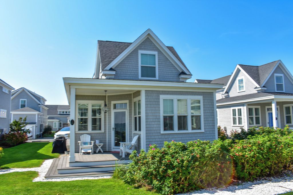 A single-story house with a covered porch, a small deck, and a well-maintained lawn.