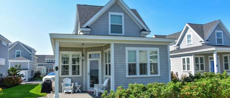 A single-story house with a covered porch, a small deck, and a well-maintained lawn.