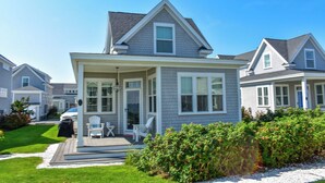 A single-story house with a covered porch, a small deck, and a well-maintained lawn.