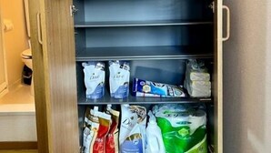 Un meuble de rangement doté de plusieurs étagères contenant divers objets d’usage courant.