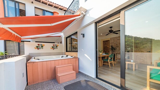 A modern bathroom with a freestanding bathtub, a wooden vanity, and a small set of steps leading to a balcony.