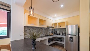 A modern kitchen with a granite countertop, stainless steel appliances, and a vase with flowers.