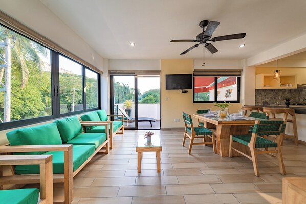 A spacious living area with a sofa, dining table, chairs, and a ceiling fan. - Centrally located condo with private plunge pool (Huatulco)