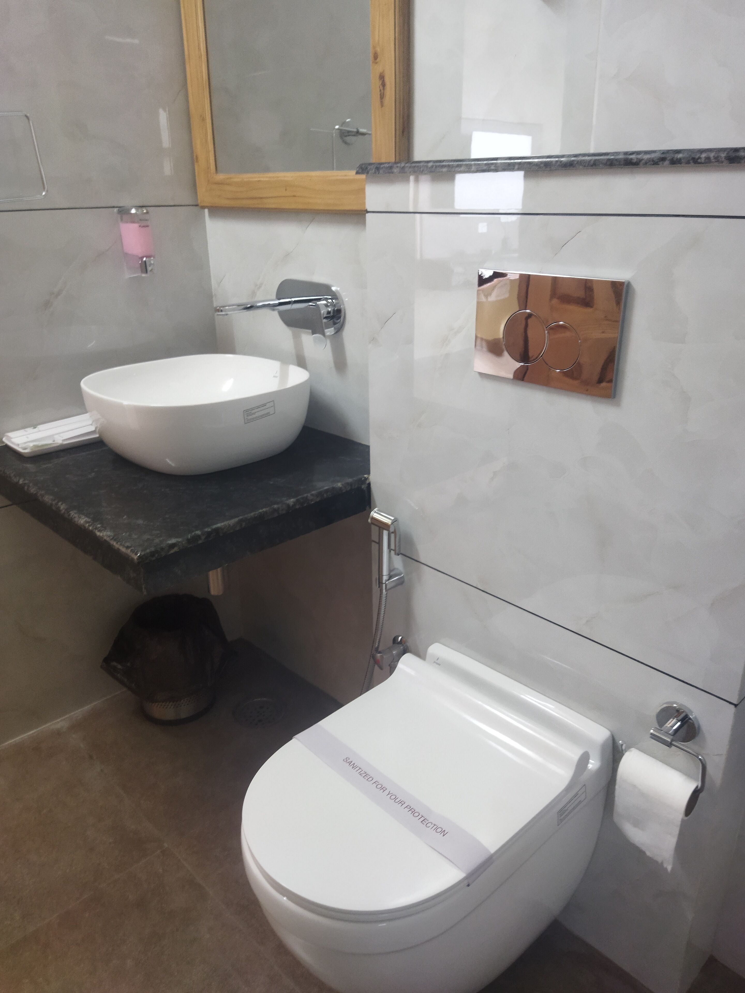 Et moderne badeværelse med en hvid vask, toilet og brusebad.