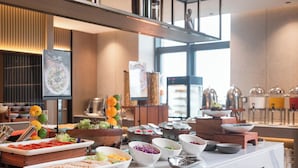Un buffet proposant divers plats et une signalétique indiquant où se trouve la salade.