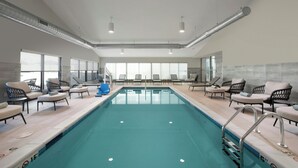 A swimming pool with lounge chairs and a view of the outdoors. - Element by Marriott Fort Smith (Fort Smith)