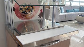 A Chobani yogurt display in a modern, well-lit room with a large window, a sofa, and a glass partition.