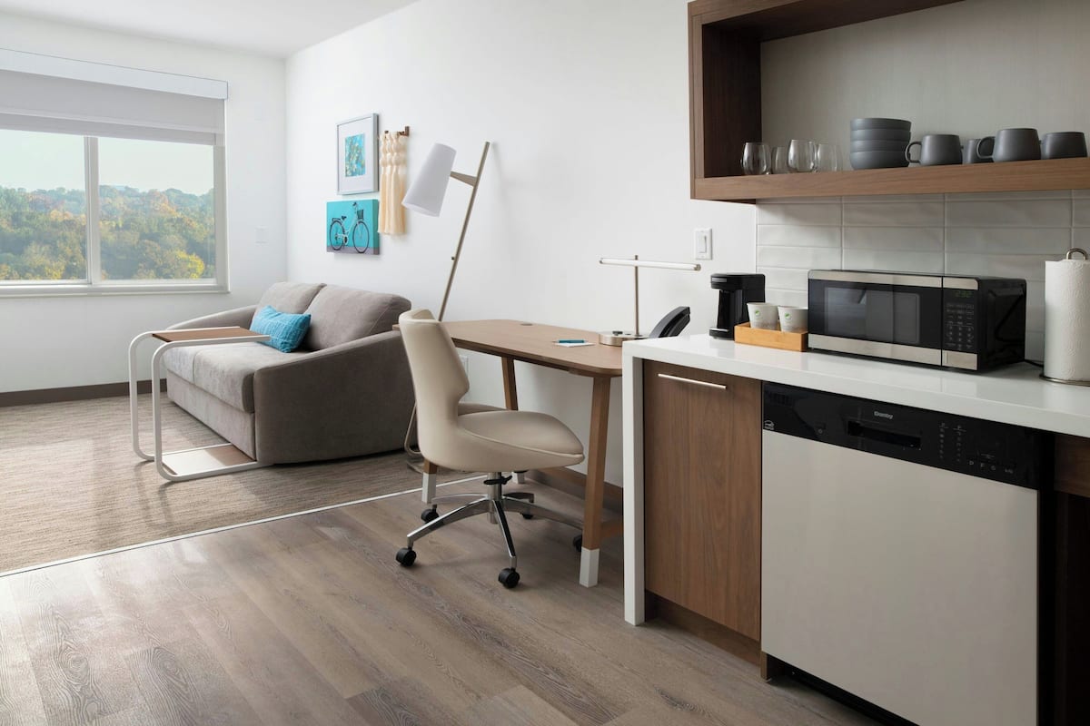 A modern kitchen with a built-in microwave, a dishwasher, and a wooden countertop.