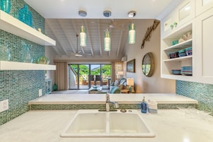 A modern bathroom with a large sink, a mirror, and a view of the outdoors.