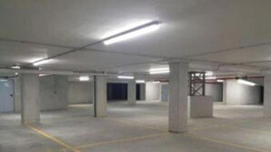 A spacious indoor parking area with concrete pillars and marked parking spaces. - shell Maqueda, bright and quiet apartment in the heart of the city (Palermo)