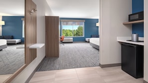 A modern hotel room with a large window, a small kitchenette, and a seating area with a view of the outdoors. - Holiday Inn Express & Suites Buford – Mall of Georgia by IHG (Buford)
