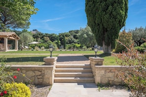A stone pathway leading to a gazebo with outdoor seating.