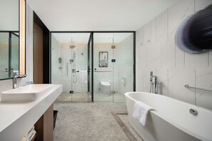 A modern bathroom with a glass-enclosed shower, a freestanding bathtub, and a large mirror.