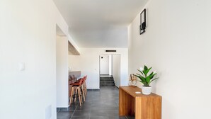 A hallway with a wooden reception desk, a potted plant, and a staircase leading to another area. - Kaz Corail Villa 4 Exceptionnelle ! (Le Vauclin)