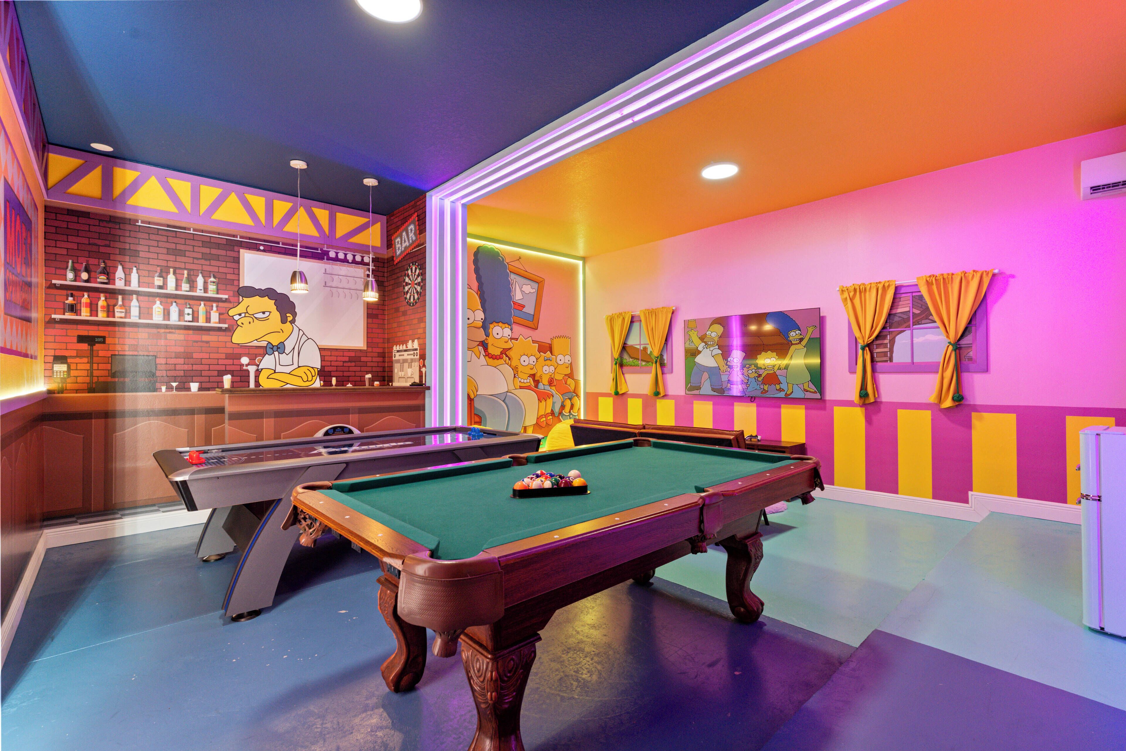 Uma mesa de bilhar em um espaço com bar e detalhes decorativos nas paredes.