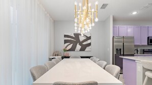 Un espace repas moderne avec une longue table et des chaises à revêtement gris.