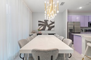 Un comedor moderno con una mesa larga y sillas tapizadas de gris.