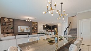 A modern kitchen with dark cabinets, a large island, and a hanging light fixture. - 9BR house sleeps 22 with private pool in kissimmee (Kissimmee)