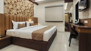 A modern hotel room with a large bed, a desk, and a television. - Kashi Vilaa (Varanasi)