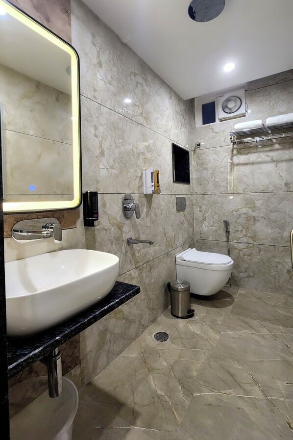 A modern bathroom with a large mirror, white sink, and a toilet. - Kashi Vilaa (Varanasi)