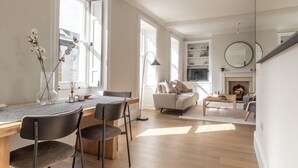 Una sala de estar moderna con un sofá, una mesa de centro y una chimenea. Hay un comedor con una mesa y sillas.