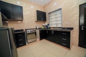 Microwave, oven, stovetop, cookware/dishes/utensils - Charming 2-Bedroom House in Ajah with AC & WiFi (ajah)