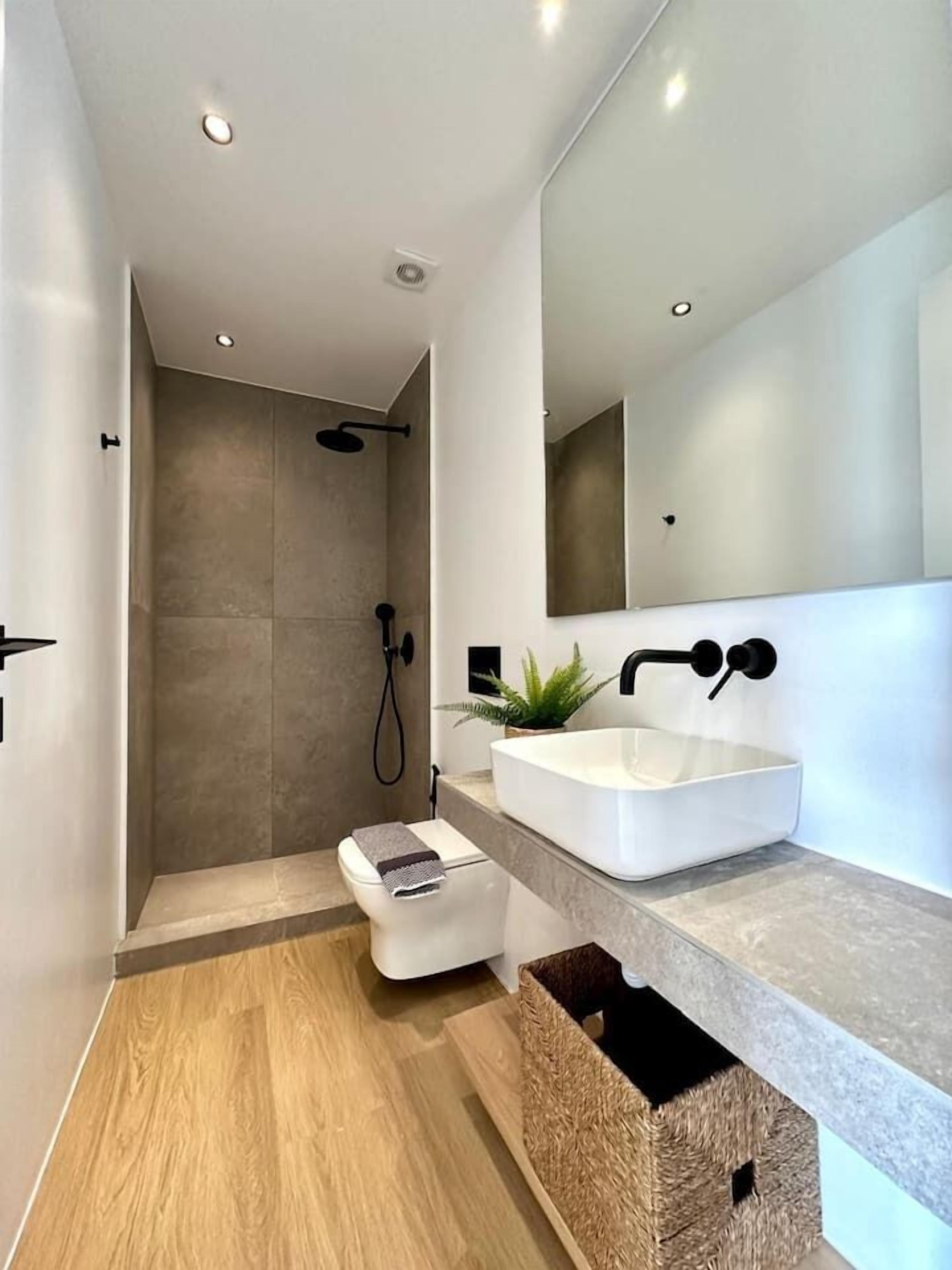 Un baño moderno con ducha, inodoro y lavamanos.