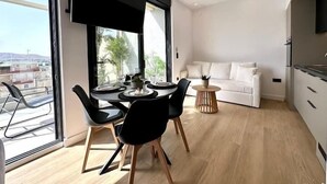 A modern apartment with a dining area, a living room, and a kitchen. - BlueMotion - CentralSuite (Piraeus)