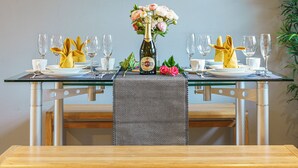 A dining table set with wine glasses, plates, and a bottle of champagne. - Queens Quarter 2-Bed | Next to City Centre - Pass the Keys (Belfast)