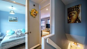 A bedroom with a bed, a wall-mounted artwork, and a door leading to another room. - Queens Quarter 2-Bed | Next to City Centre - Pass the Keys (Belfast)