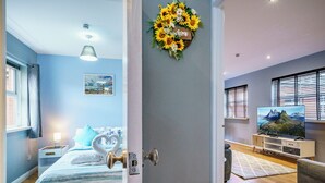 A modern living room with a flat-screen TV, a sofa, and a coffee table. - Queens Quarter 2-Bed | Next to City Centre - Pass the Keys (Belfast)