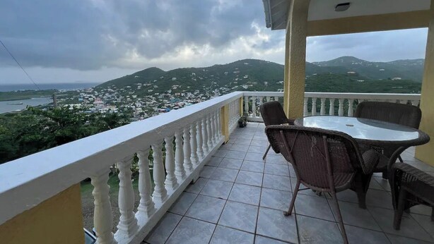 Un balcone con vista su una città e montagne.