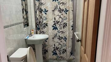 Een douche, een bubbelbad, een bidet, handdoeken