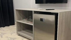 A compact minibar with a television above it, a small refrigerator, and a shelf with items. - Habu Pyramids View Hotel (Giza)