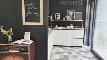 Une cuisine moderne avec un tableau noir sur lequel est écrit « PETIT-DÉJEUNER » et une radio ancienne.