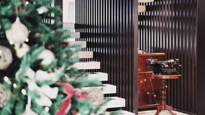 A room with a wooden desk, a vintage typewriter, and a Christmas tree. - CASA ESTER (Baselga di Pine)