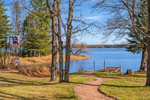 A lakeside trail leading to a lodge with a sign indicating a fishing area.